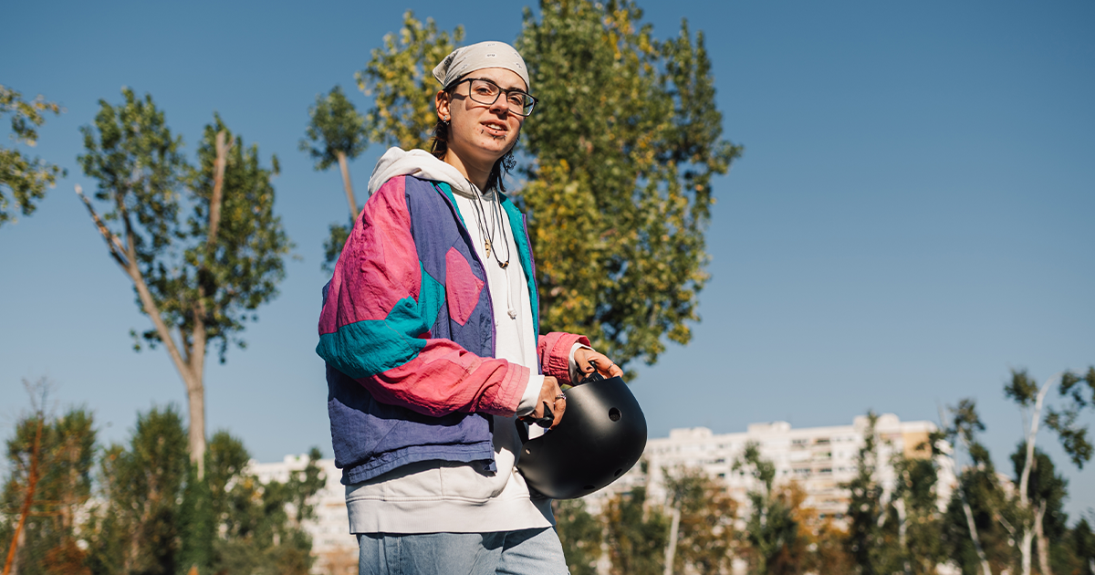 Person in pink and blue jacket outside in the sun